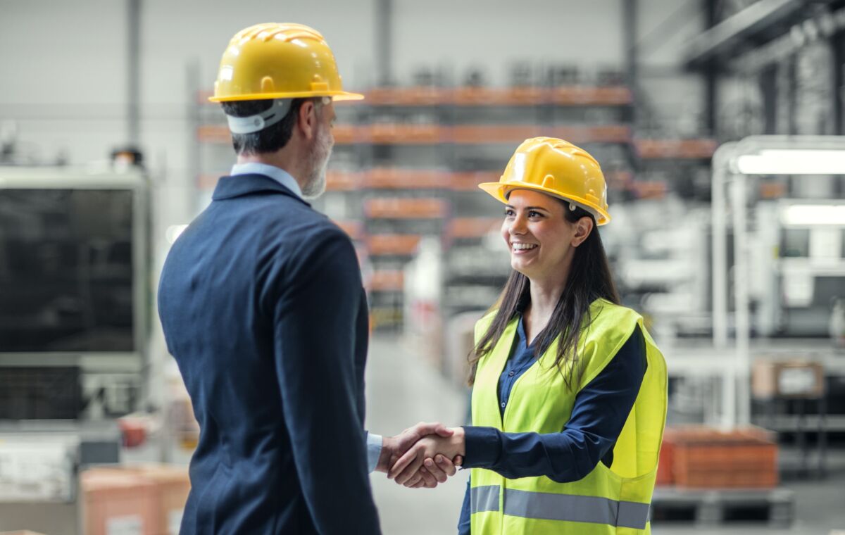 man and woman in hard hats shaking hands