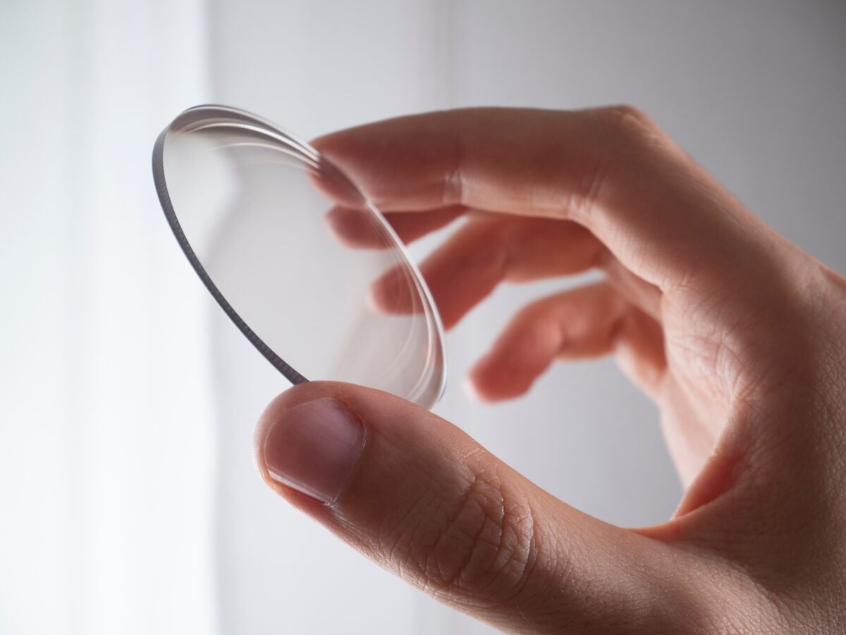 Hand holding lens eyeglass, modern manufacturing